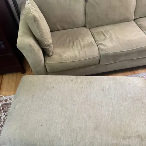 Olive sofa and ottoman with spots and dark patches before cleaning